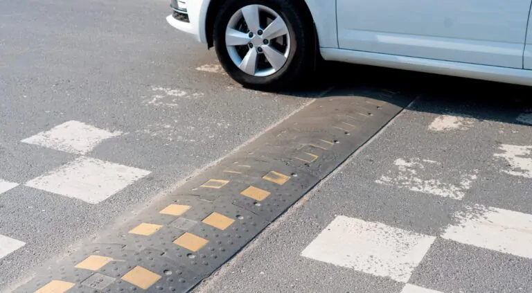 Car moving over speed bump on busy road