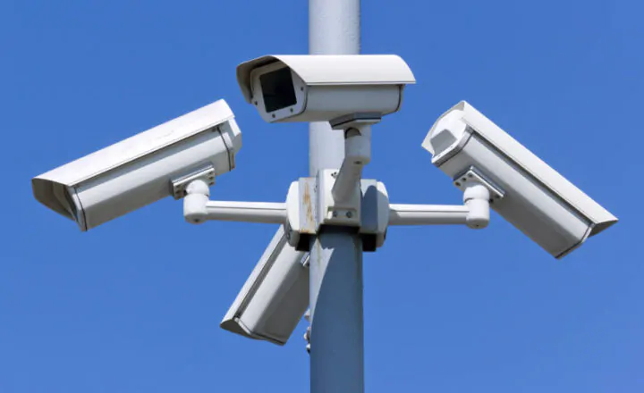 Four security cameras on blue sky