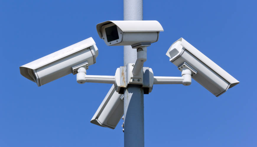Four security cameras on blue sky