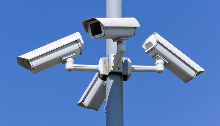 Four security cameras on blue sky