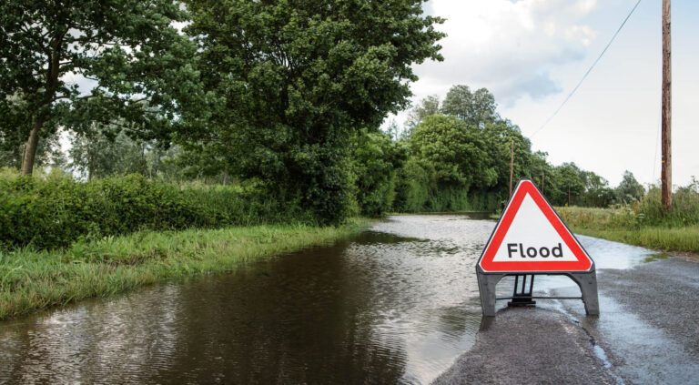 country road in UK with flood warning sign