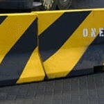 Yellow and black striped traffic barrier with a ‘One Way’ arrow directing vehicles
